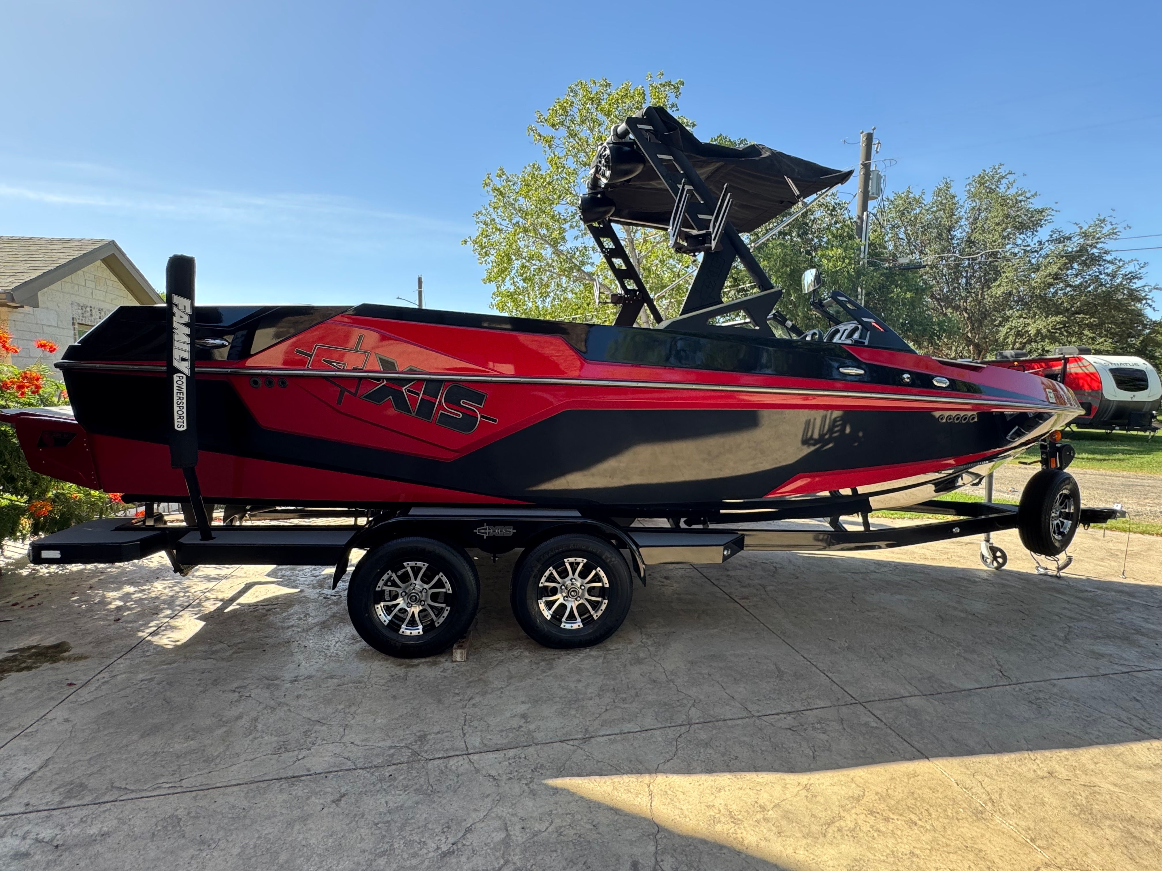 Axis T23 2019 Axis T23 boat in red and black on a trailer, parked outdoors.