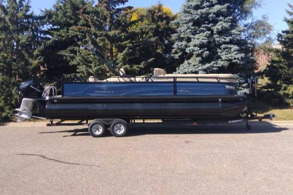 Regency 250 DL3 2023 Regency 250 DL3 pontoon boat on trailer, parked outdoors.