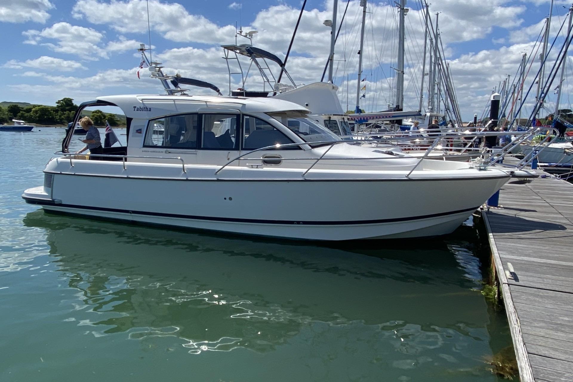 Nimbus 335 Coupe 2013 Nimbus 335 Coupe docked at marina under blue sky.