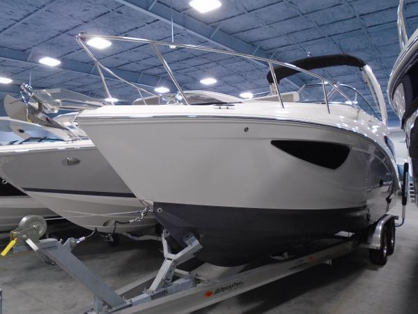 Regal 26 XO 2025 Regal 26 XO boat on trailer in showroom, under bright lighting.