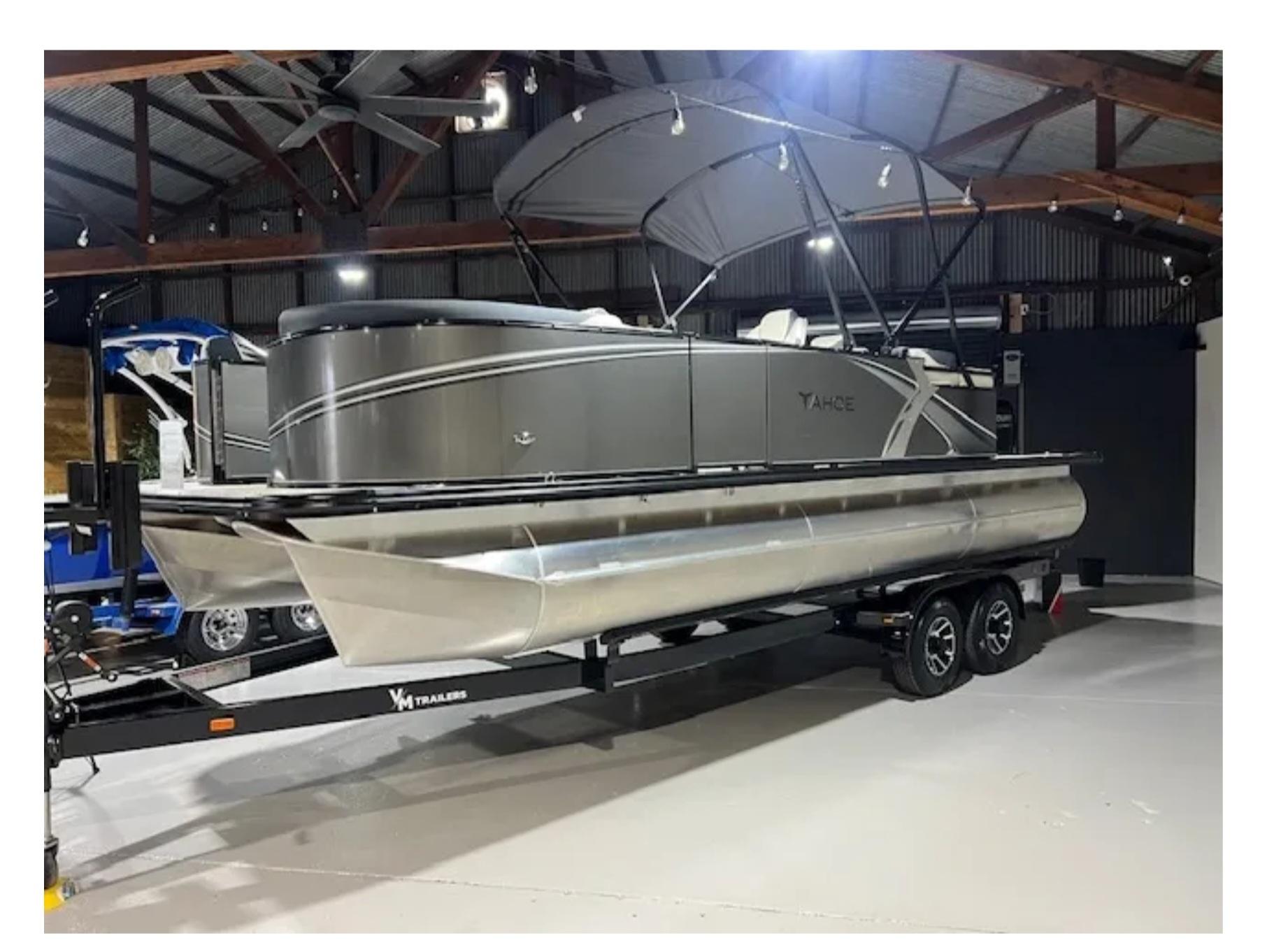 Tahoe ltz 2025 Tahoe LTZ pontoon boat on trailer in indoor showroom.