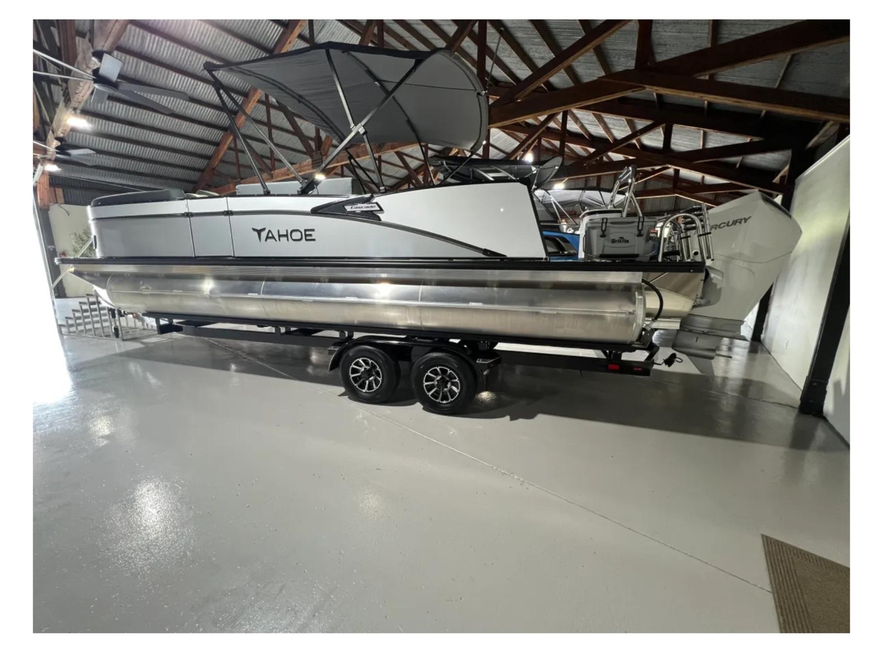 Tahoe CASCADE 2025 Tahoe CASCADE pontoon boat in a warehouse, featuring a sleek design and modern outboard motor.