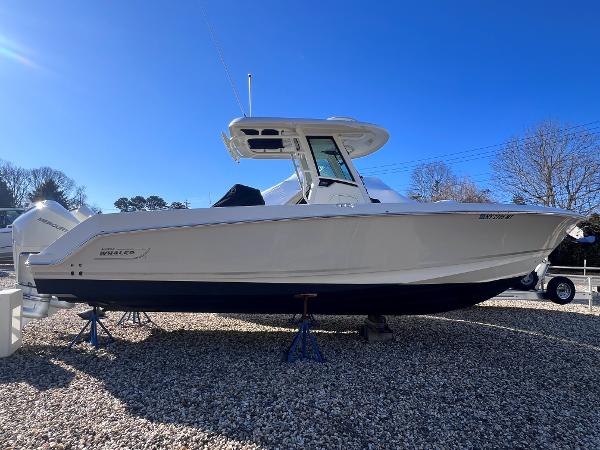 Boston Whaler 280 Outrage 2022 Boston Whaler 280 Outrage boat on gravel, clear blue sky background.