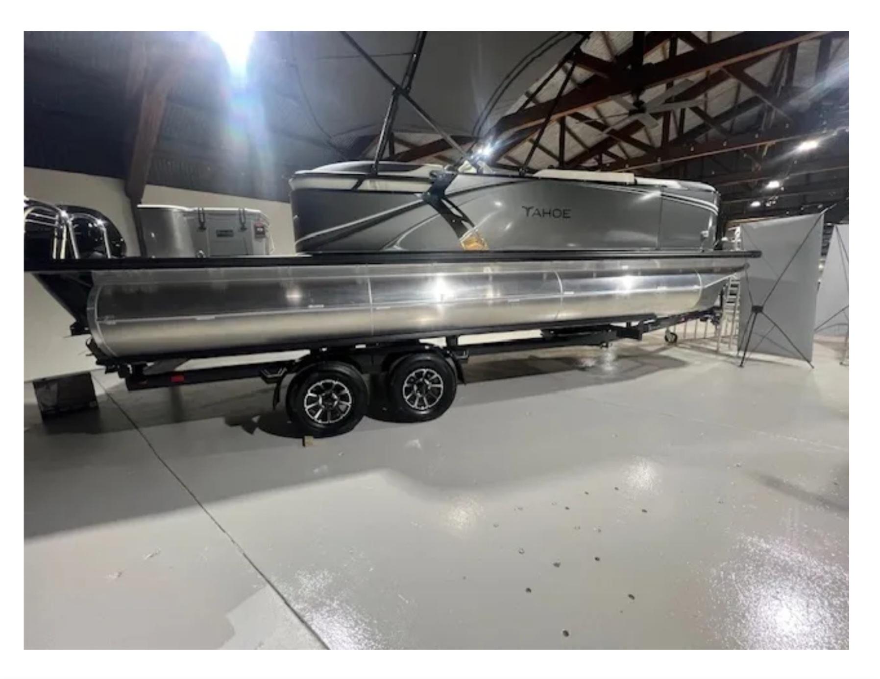 Tahoe ltz 2025 Tahoe LTZ pontoon boat on trailer in indoor showroom.