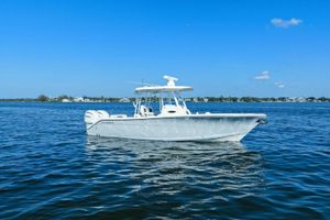 Cobia 301 Center Console 2023 Cobia 301 Center Console boat on calm blue water under clear sky.