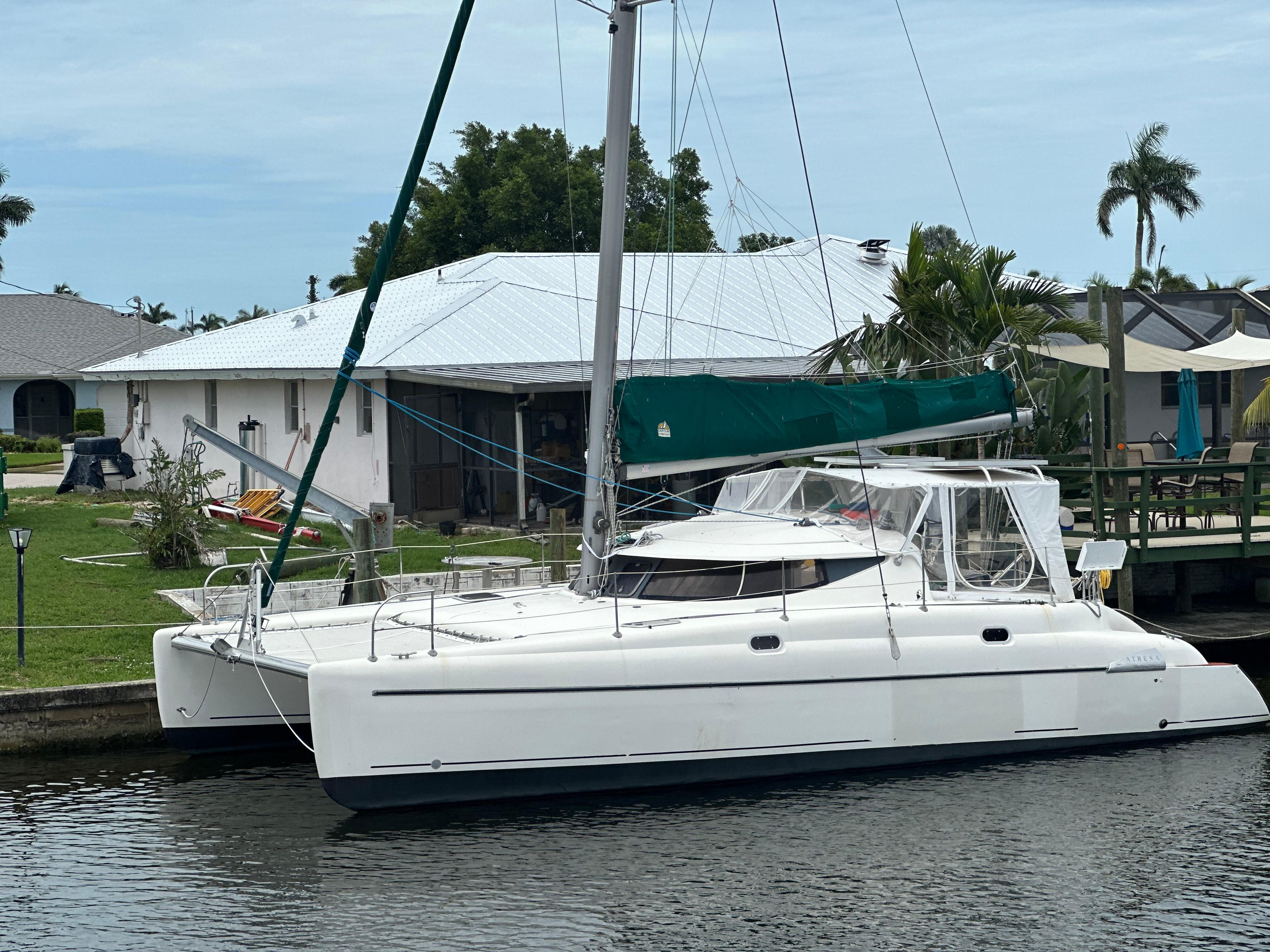 Fountaine Pajot Athena 38 1998 Fountaine Pajot Athena 38 catamaran docked by a waterfront home.