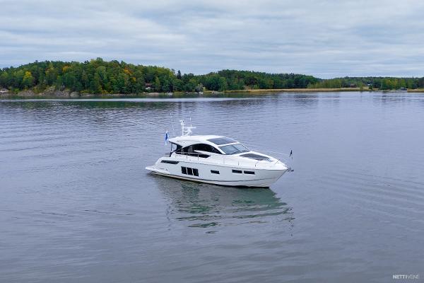 Fairline Targa 48 GT 2014 Fairline Targa 48 GT yacht cruising on a calm lake with forested shoreline.