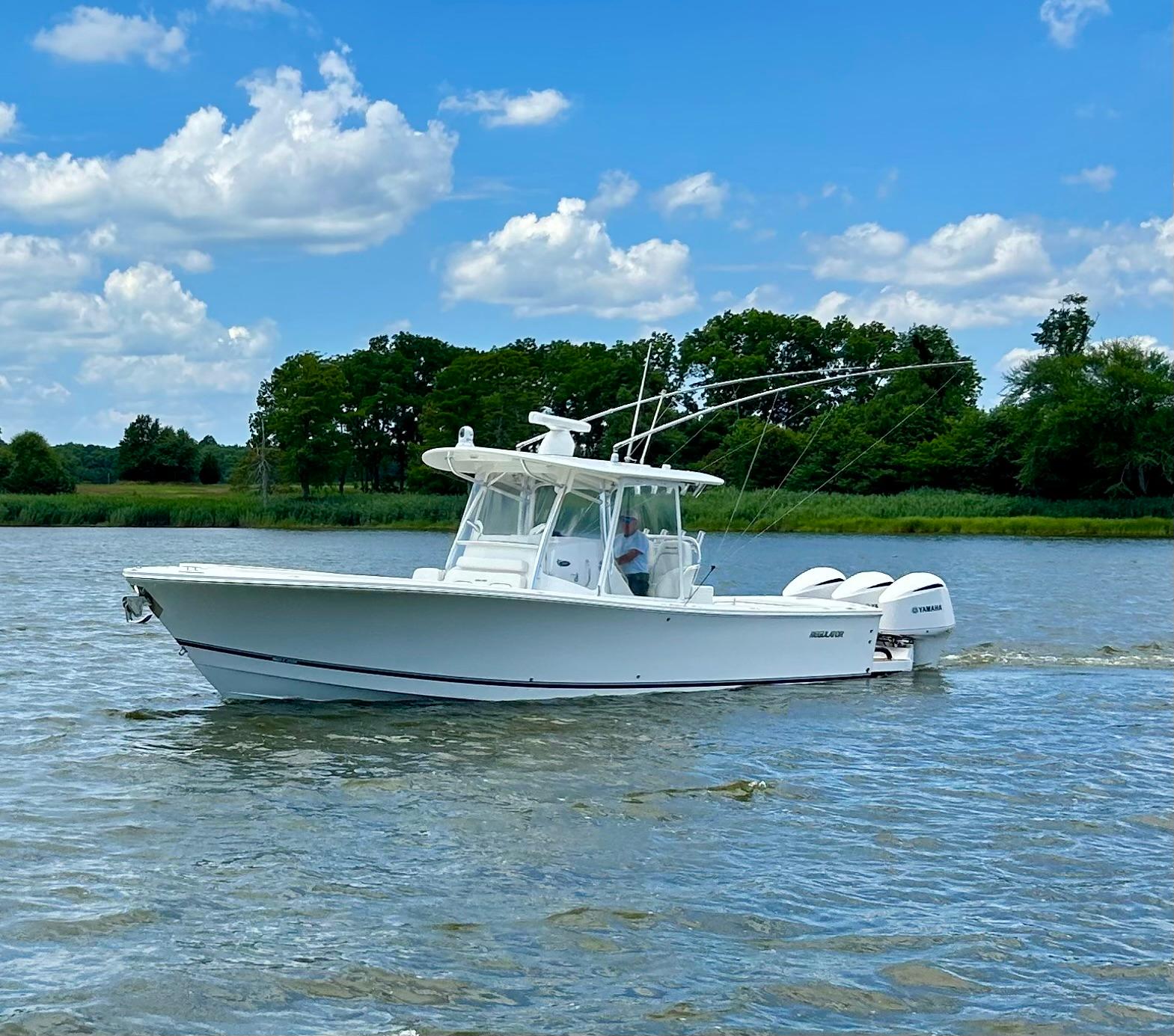 Regulator 34SS 2016 Regulator 34SS boat cruising on a calm lake under a clear blue sky.