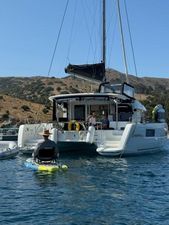 Lagoon 40 2021 Lagoon 40 catamaran anchored in scenic bay with kayaker nearby.