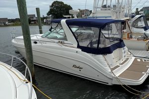 Rinker 342 2004 Rinker 342 boat docked with blue canopy, in a marina setting.