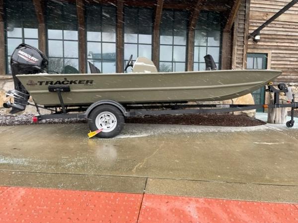 Tracker Grizzly 1754 SC 2024 Tracker Grizzly 1754 SC boat on trailer outside wooden building.