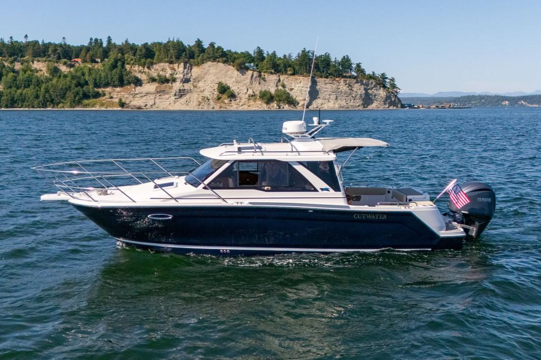 Cutwater C-248 Coupe 2026 Cutwater C-248 Coupe cruising on a scenic lake with rocky shoreline.