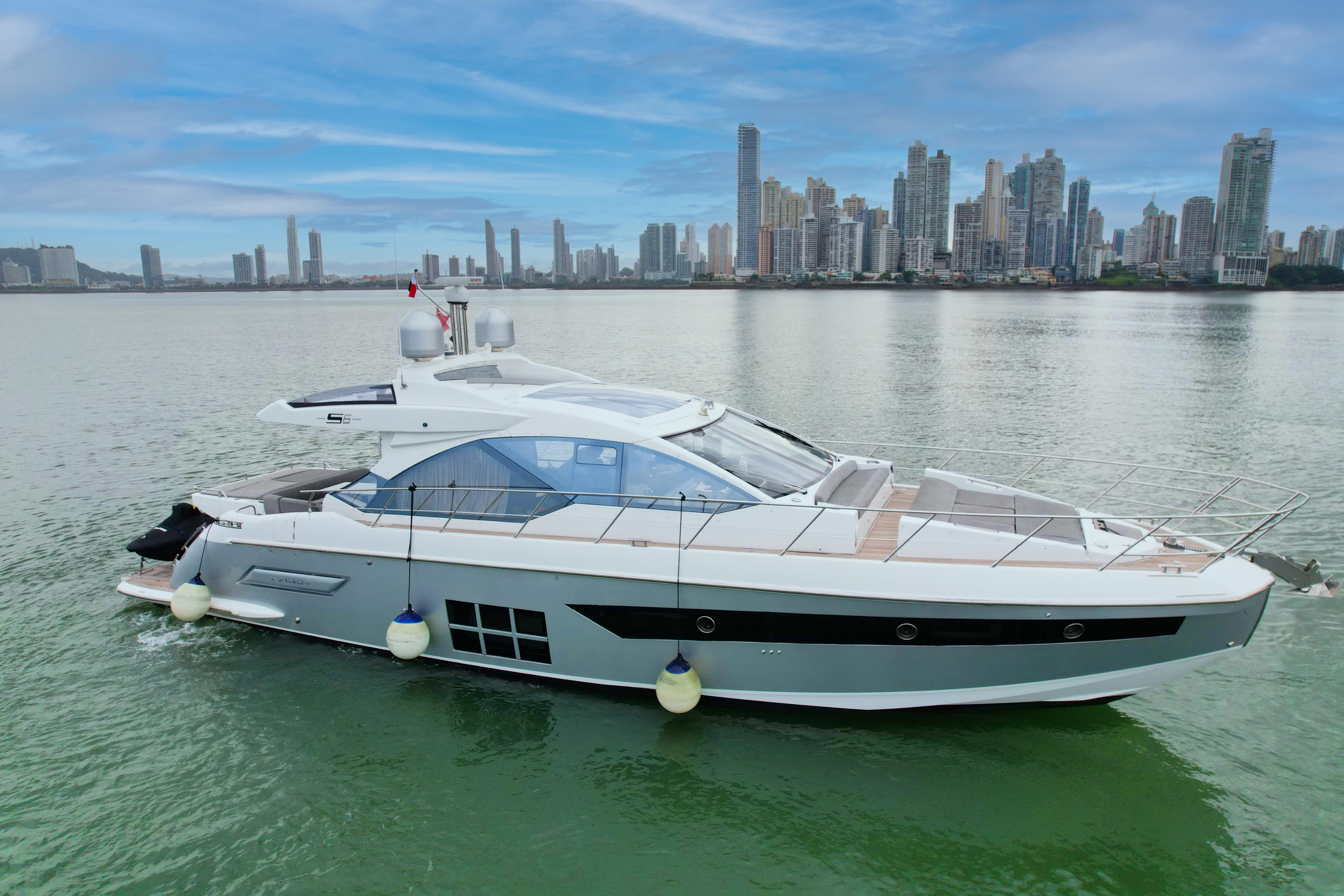 Azimut S6 2019 Azimut S6 yacht cruising near a city skyline on calm waters.