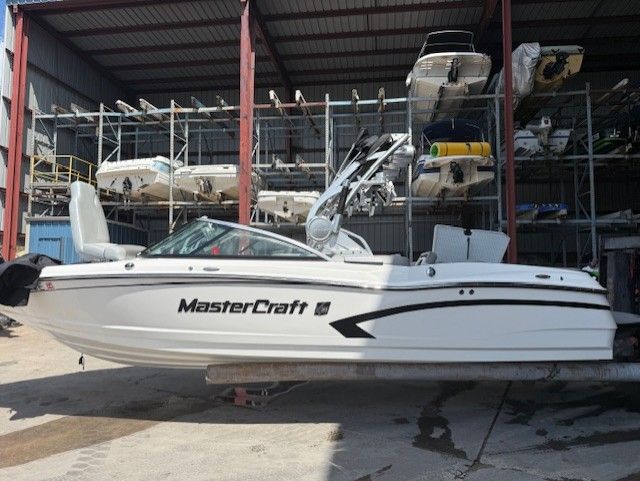 MasterCraft X-30 2014 MasterCraft X-30 boat in storage facility, surrounded by other boats.