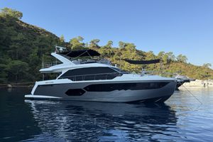 Absolute 58 FLY Luxury Absolute 58 FLY yacht, 2017 model, anchored in serene waters with lush greenery backdrop.