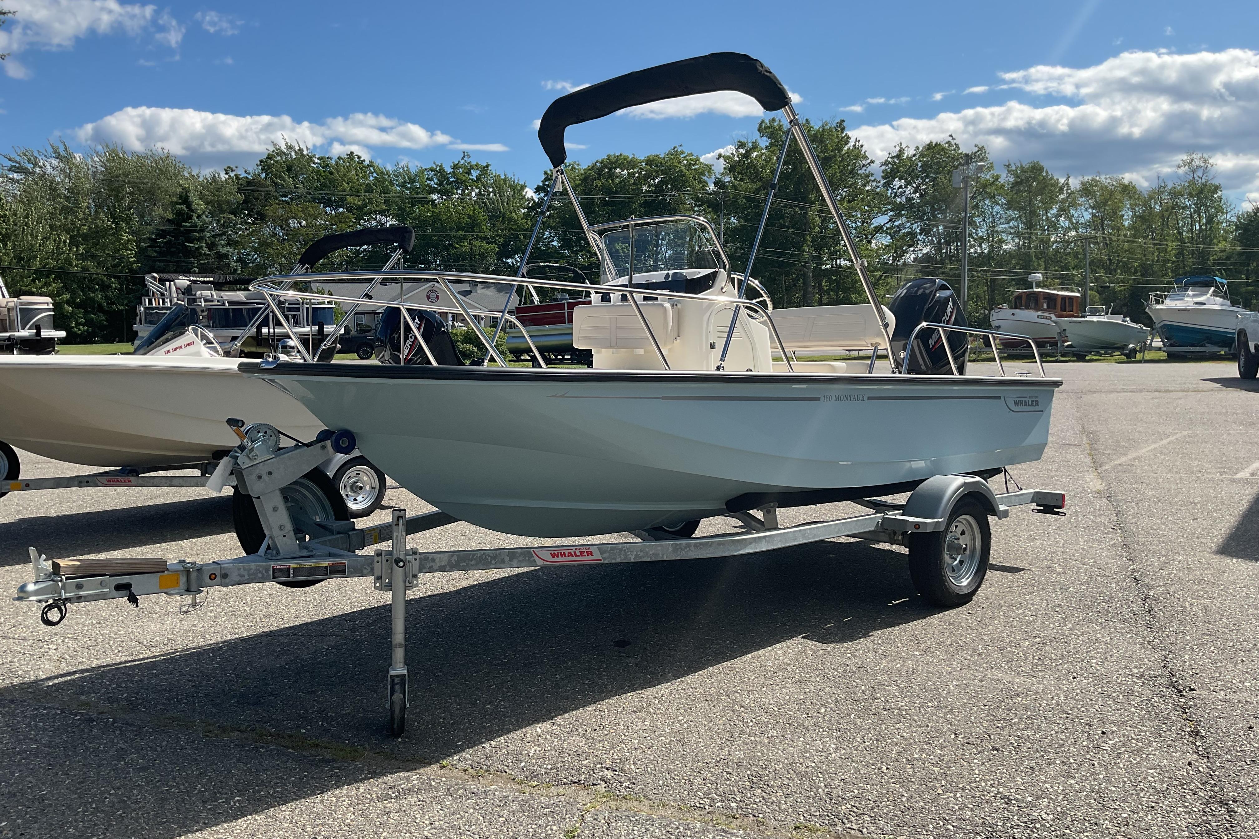 Boston Whaler 150 Montauk 2025 Boston Whaler 150 Montauk boat on trailer under clear blue sky.