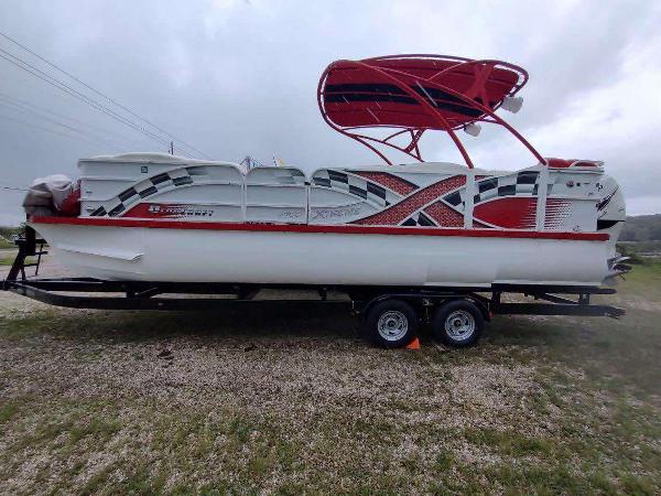 PlayCraft 2600 X-treme 2017 PlayCraft 2600 X-treme pontoon boat with red and white design on a trailer.