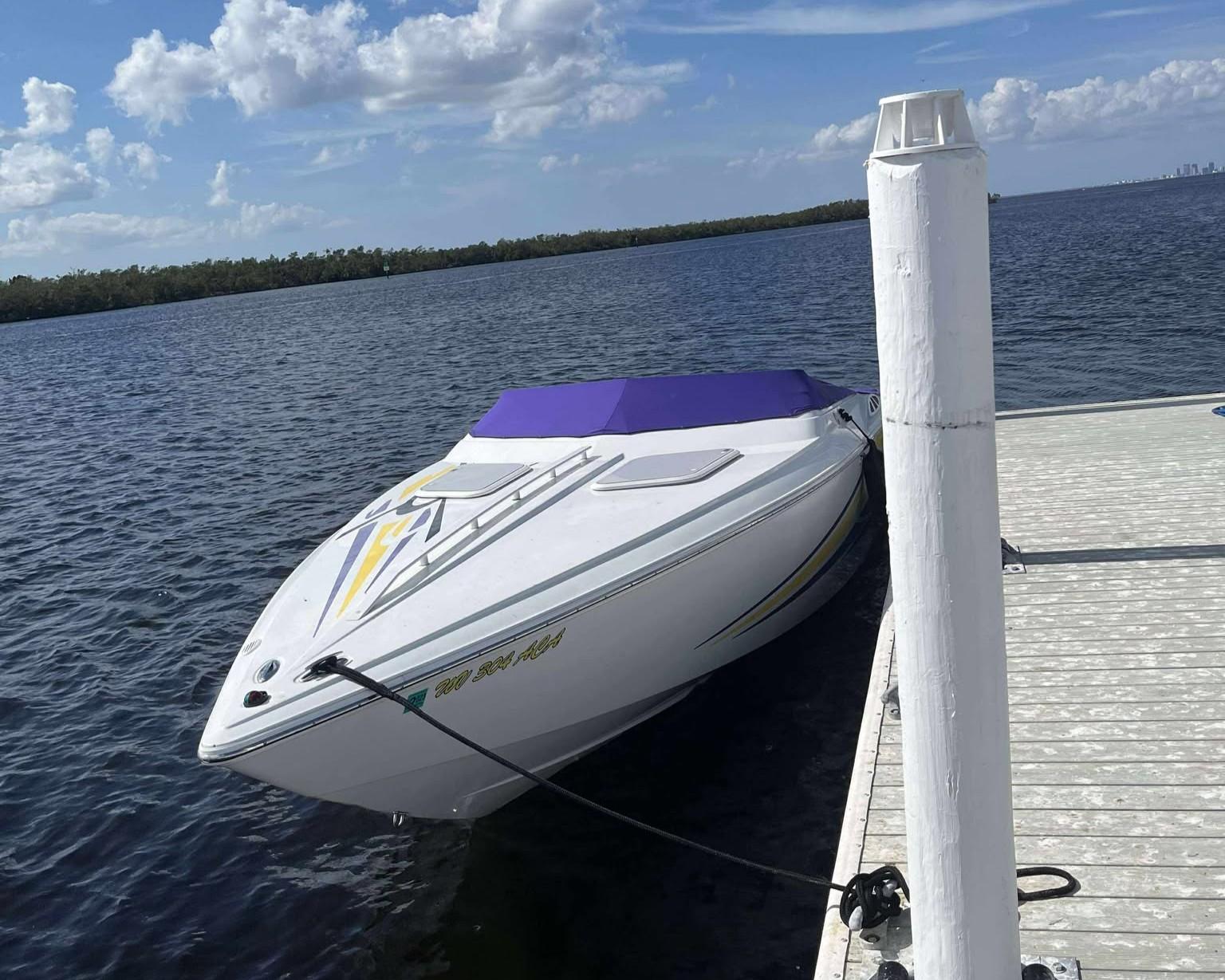 Baja 25 Outlaw 2005 Baja 25 Outlaw speedboat docked on a sunny day, calm waters, blue sky.