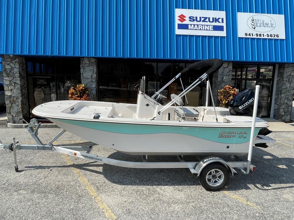 Carolina Skiff 17 LS 2025 Carolina Skiff 17 LS boat on trailer outside Suzuki Marine dealership.