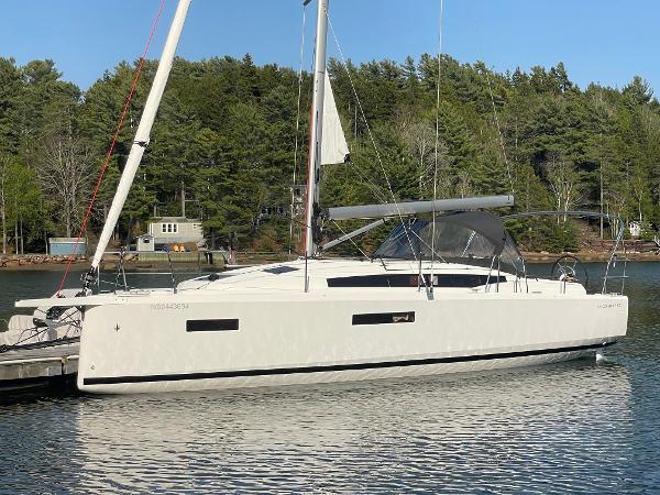 Jeanneau Sun Odyssey 380 2024 Jeanneau Sun Odyssey 380 sailboat docked on calm water, surrounded by trees.