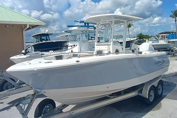 Robalo R230 Center Console 2025 Robalo R230 Center Console boat on trailer, dockside under blue sky.