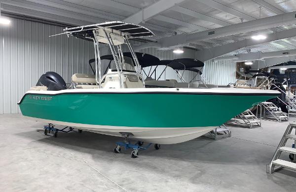 Key West 203 FS 2024 Key West 203 FS boat in showroom, teal hull, T-top, and dual outboard engines.