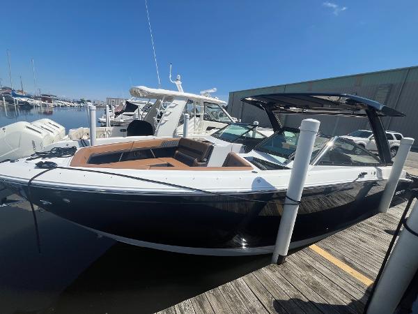 Cobalt R33 2024 Cobalt R33 boat docked at marina, featuring sleek design and spacious seating.