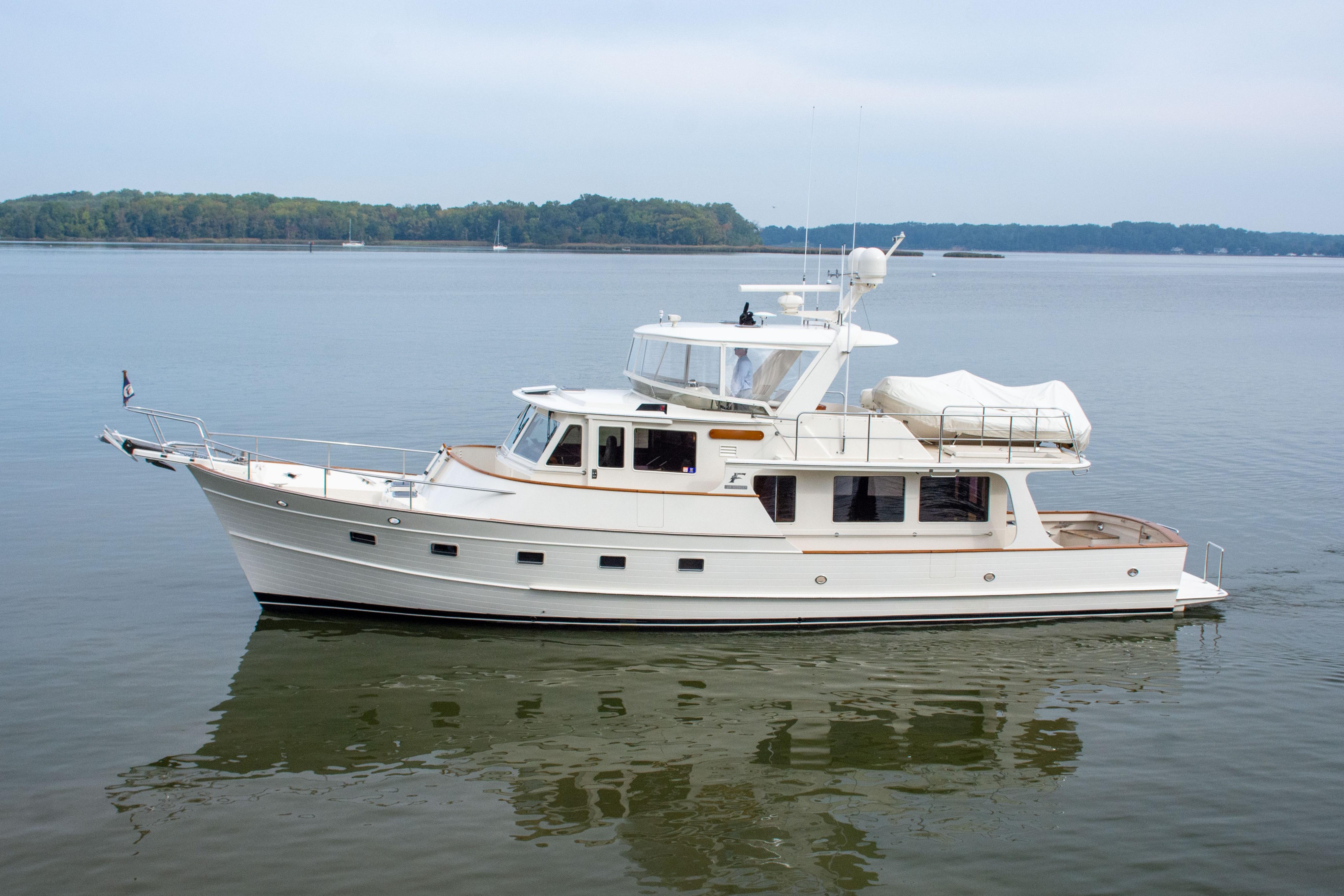 Fleming 55 2016 Fleming 55 yacht cruising on calm waters with scenic background.