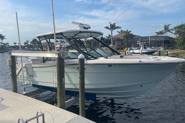 Robalo R317 Dual Console 2023 Robalo R317 Dual Console boat docked in a marina with palm trees.