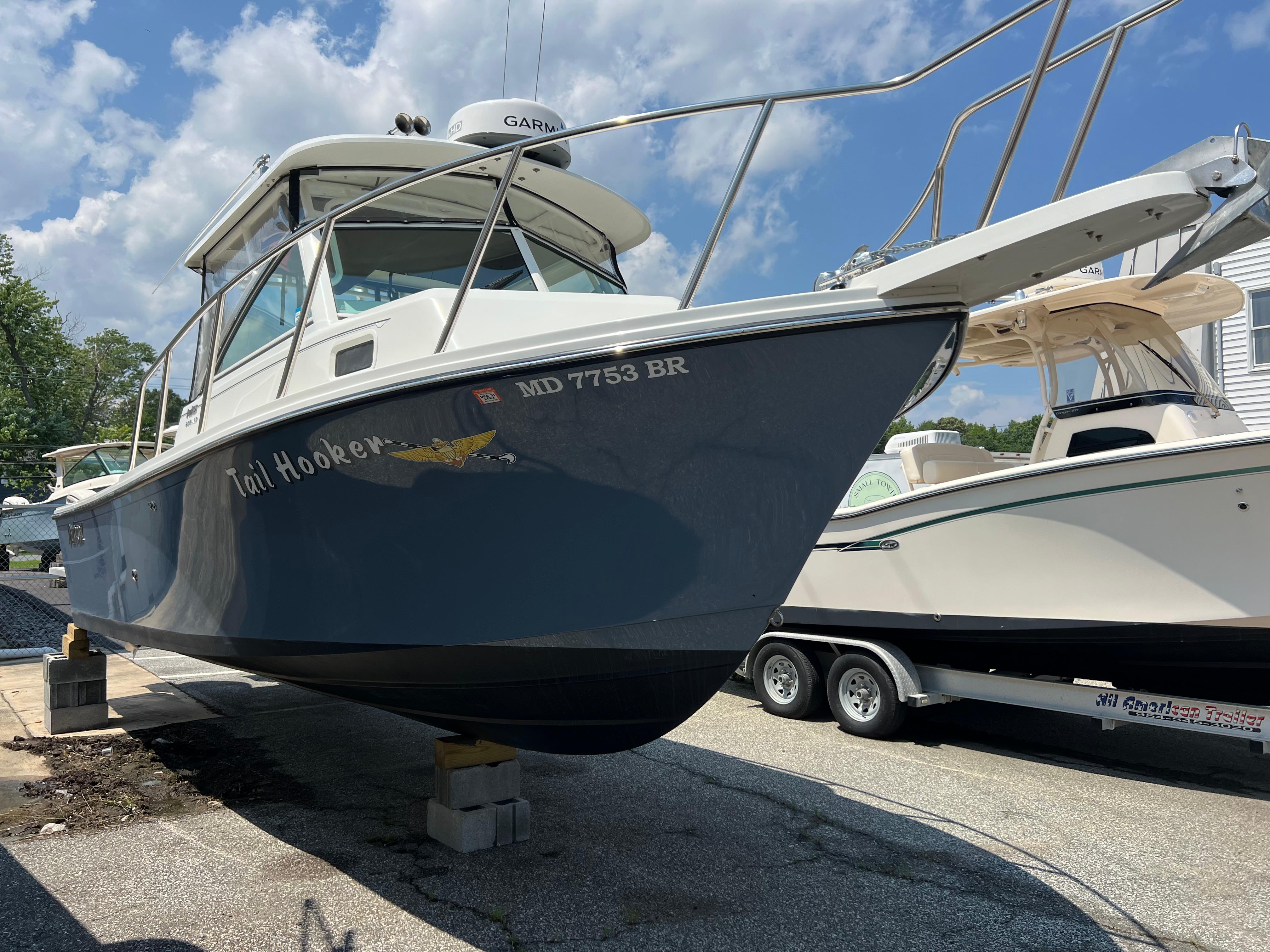 Parker 2510 XL Walkaround 2021 Parker 2510 XL Walkaround boat on trailer, blue hull, clear sky background.