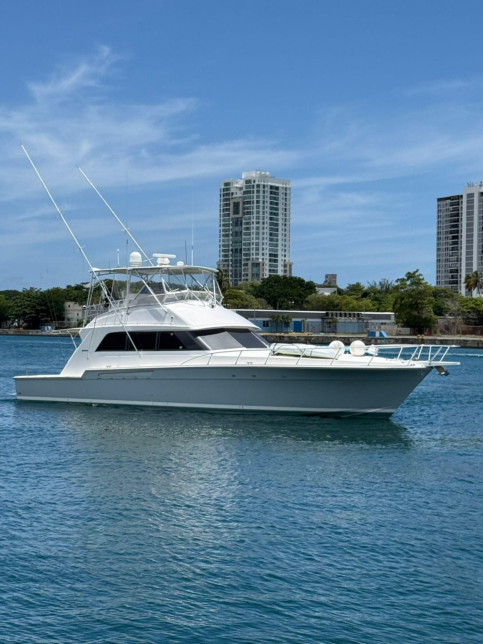 Bertram 60 Convertible 1995 Bertram 60 Convertible yacht cruising on blue water near urban skyline.