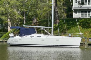 Beneteau Oceanis 393 2002 Beneteau Oceanis 393 sailboat docked by lush greenery.