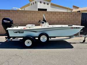 Mako Pro Skiff 15 CC 2024 Mako Pro Skiff 15 CC boat on trailer, parked outdoors.