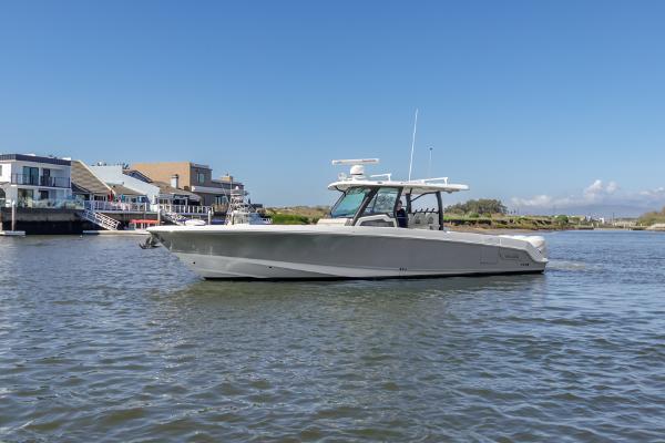 Boston Whaler 380 Outrage 2021 Boston Whaler 380 Outrage boat on calm water near waterfront homes.