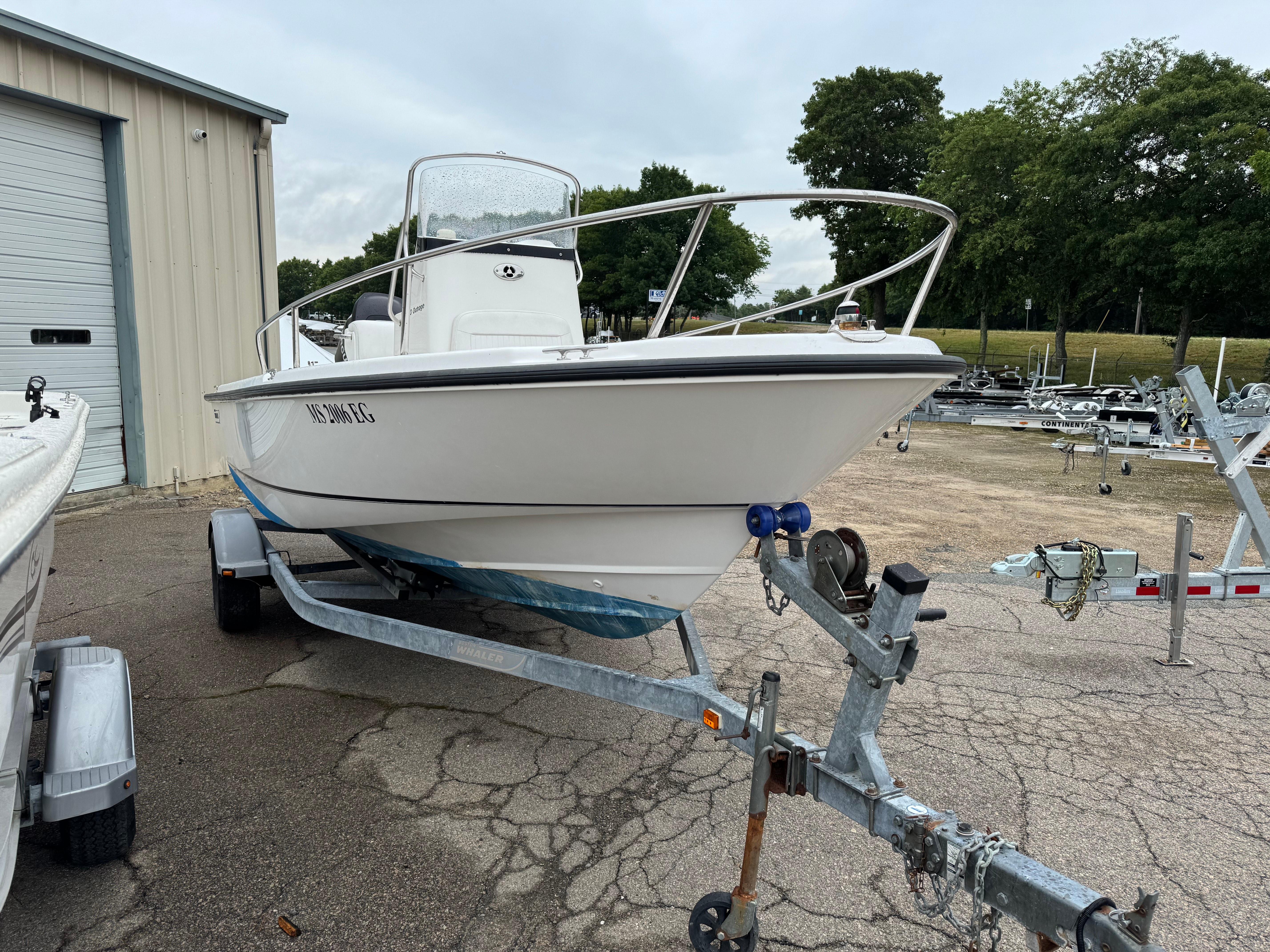 Boston Whaler 190 Outrage 2006 Boston Whaler 190 Outrage boat on trailer, parked near a storage facility.