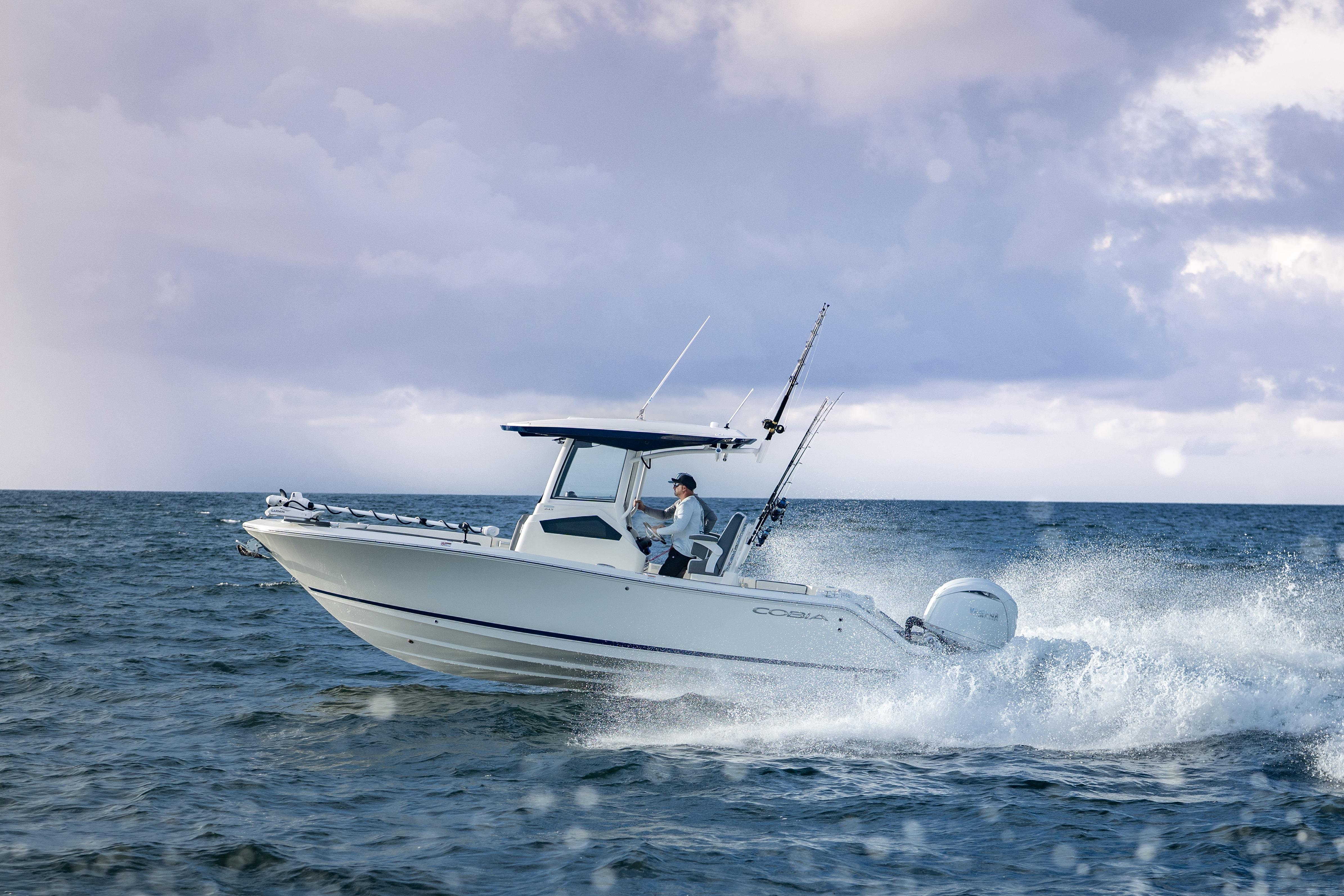 Cobia 245 Center Console 2026 Cobia 245 Center Console boat navigating ocean waves under cloudy sky.