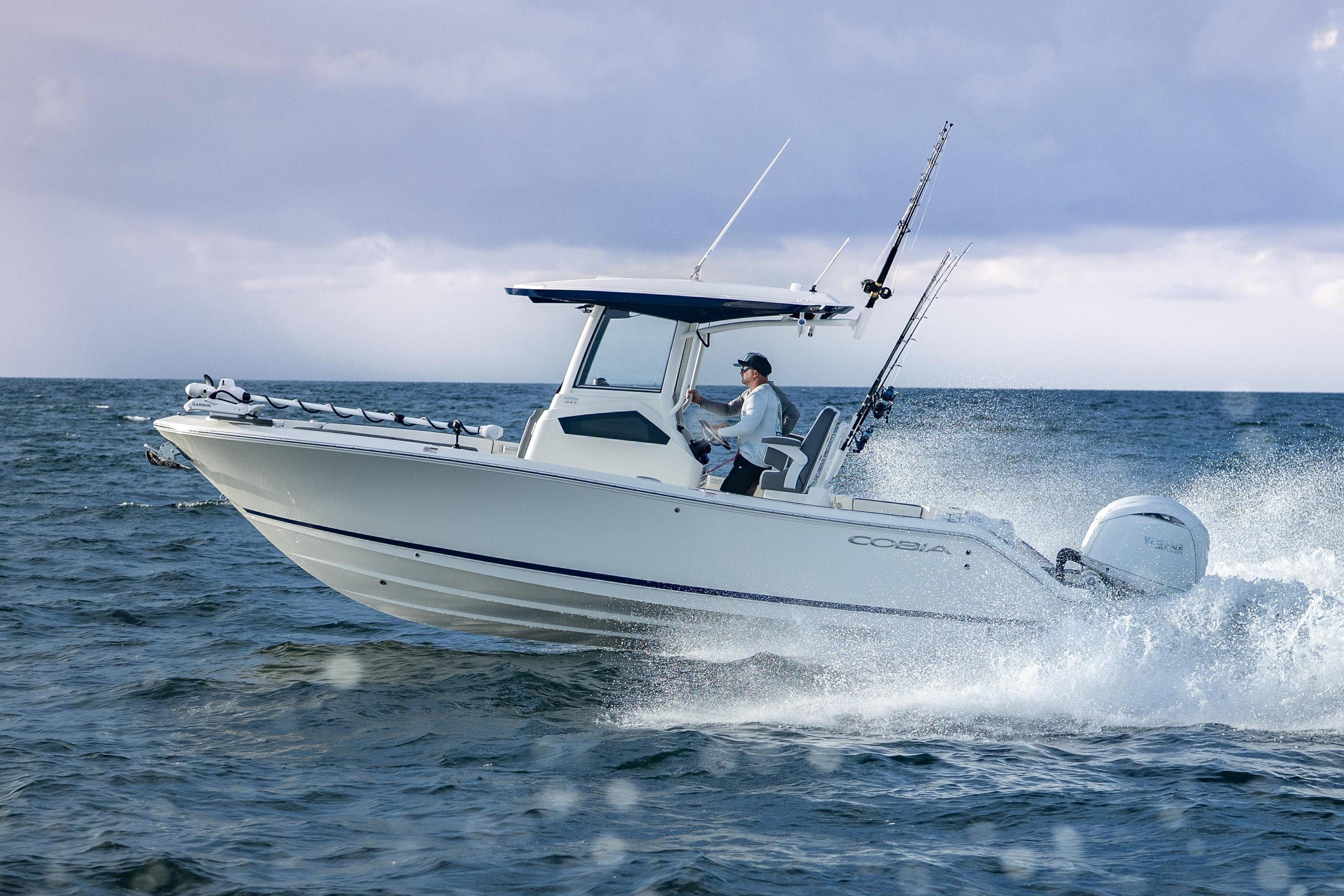 Cobia 245 Center Console 2026 Cobia 245 Center Console boat navigating ocean waves under cloudy sky.