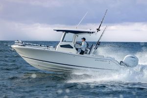 Cobia 245 Center Console 2026 Cobia 245 Center Console boat navigating ocean waves under cloudy sky.