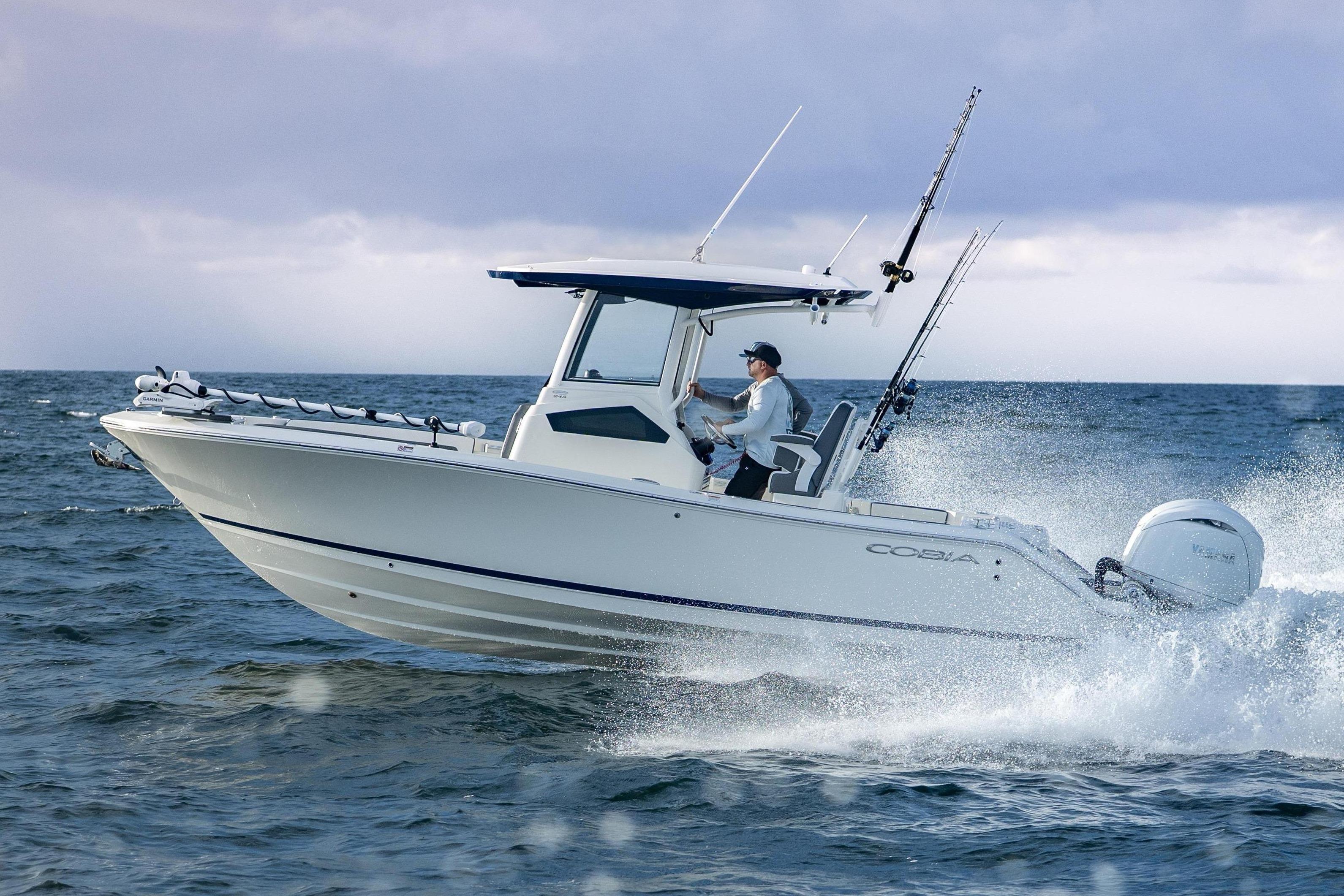 Cobia 245 Center Console 2026 Cobia 245 Center Console boat navigating ocean waves under cloudy sky.