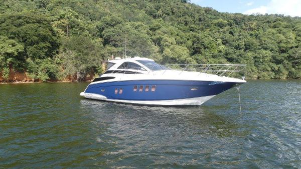 Regal 42 Sport Coupe 2015 Regal 42 Sport Coupe yacht on a serene lake with lush green forest background.
