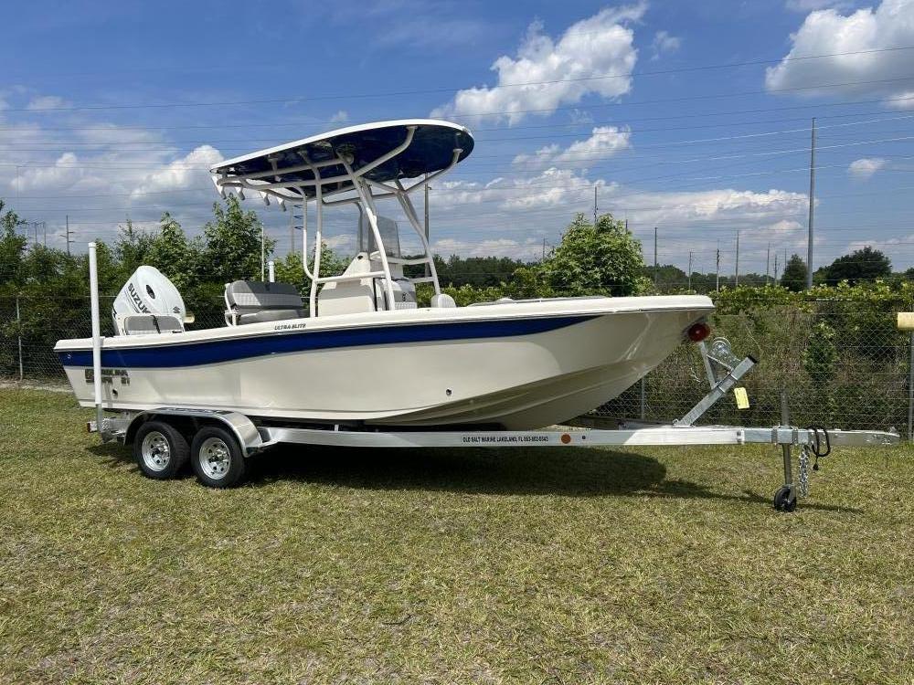 Carolina Skiff 21 Ultra Elite 2024 Carolina Skiff 21 Ultra Elite boat on trailer, parked on grass under blue sky.
