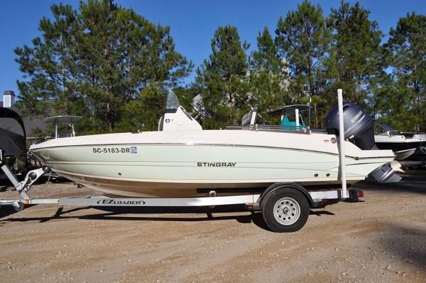 Stingray 186 CC 2021 Stingray 186 CC boat on trailer, parked outdoors with trees in background.