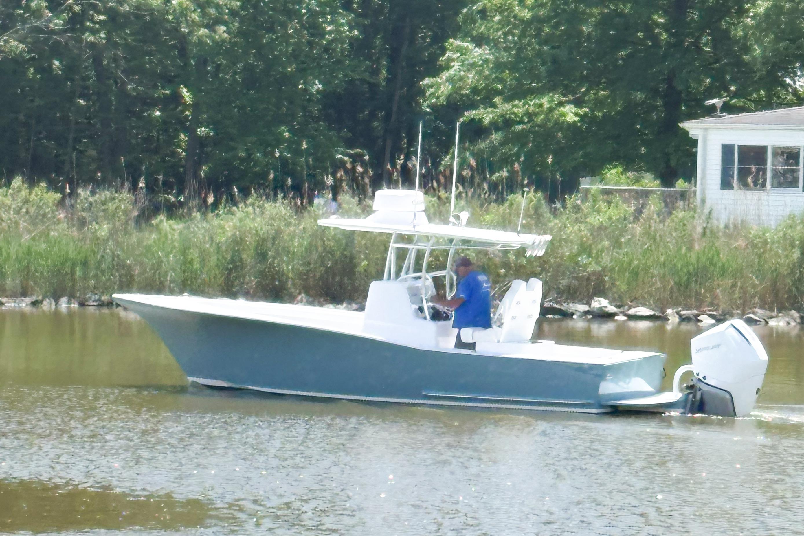 Weaver 270 2025 Weaver 270 boat cruising on a calm river near a wooded shoreline.