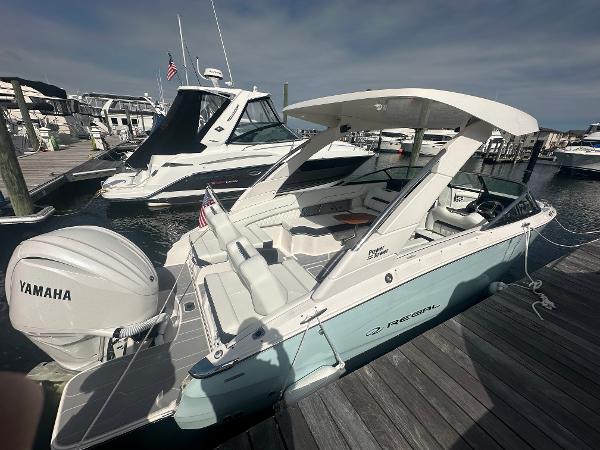 Regal LX6 2024 Regal LX6 boat docked with Yamaha engine, sleek design, and spacious seating.