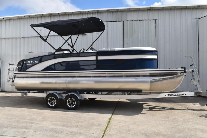 Lowe SS 230 WV TL 2025 Lowe SS 230 WV TL pontoon boat on trailer, parked by a metal building.