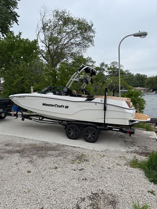MasterCraft XT22 2022 MasterCraft XT22 boat on trailer by lakeside.