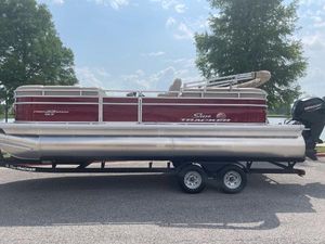 Sun Tracker Party Barge 22 DLX 2025 Sun Tracker Party Barge 22 DLX pontoon boat on trailer, parked outdoors.