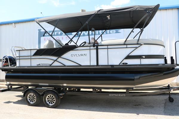 Sylvan Mirage X3 Party Fish 2025 Sylvan Mirage X3 Party Fish pontoon boat on trailer, black canopy, outdoor display.