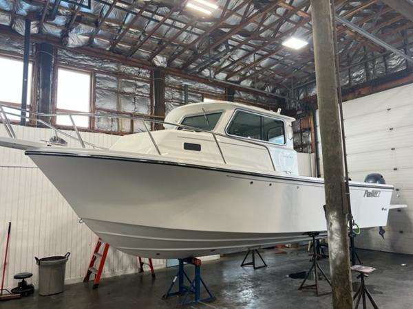 Parker 2520 XLD Sport Cabin 2024 Parker 2520 XLD Sport Cabin boat in a warehouse.