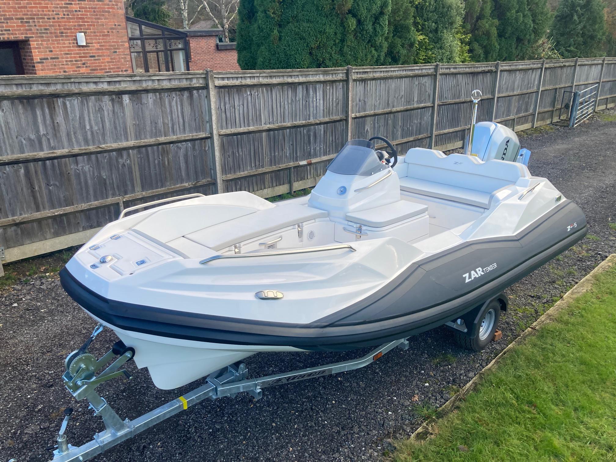 Zar Formenti ZF-5 2024 Zar Formenti ZF-5 boat on trailer, parked outdoors near wooden fence.